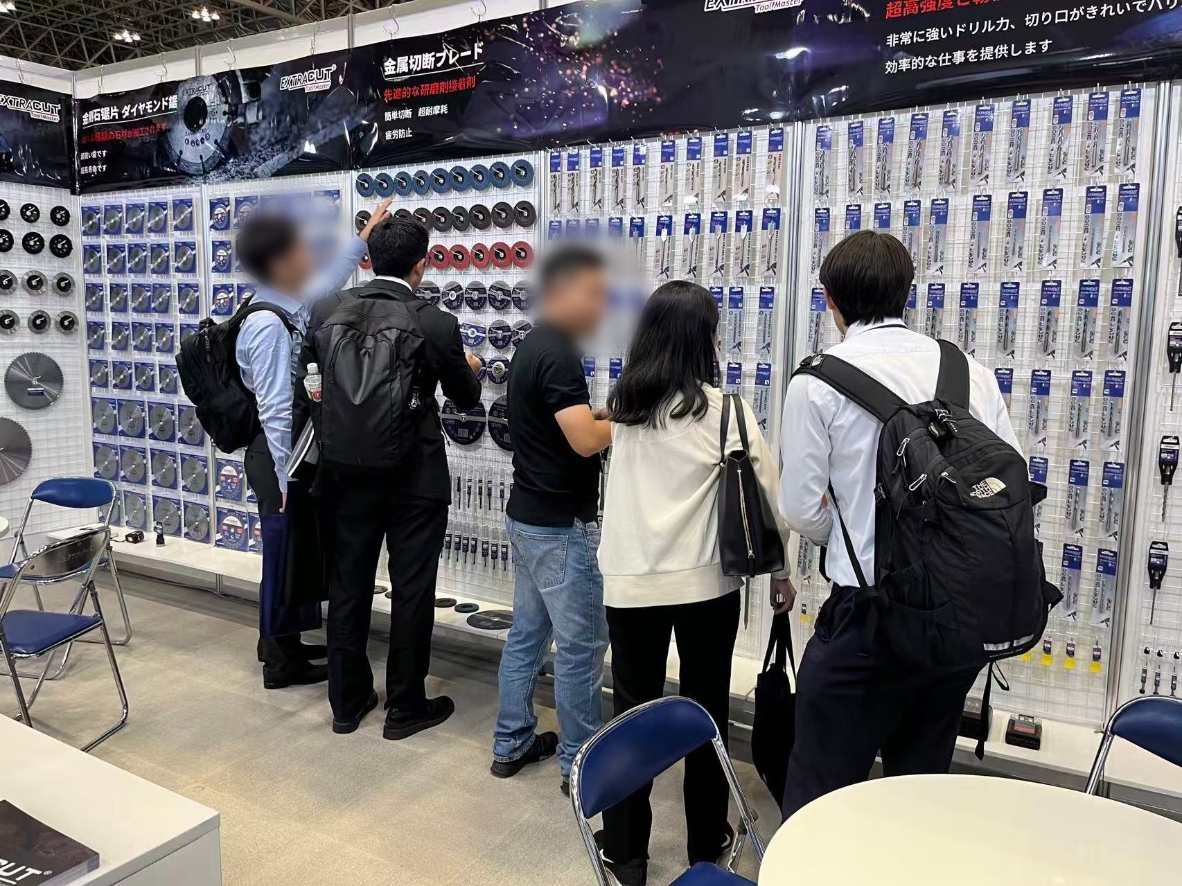 Visitors discussing diamond blades at the EXTRACUT booth, TOOL JAPAN