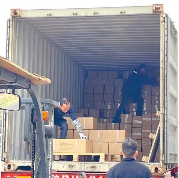 Workers hand-stacking cartons inside the container to the approved loading plan