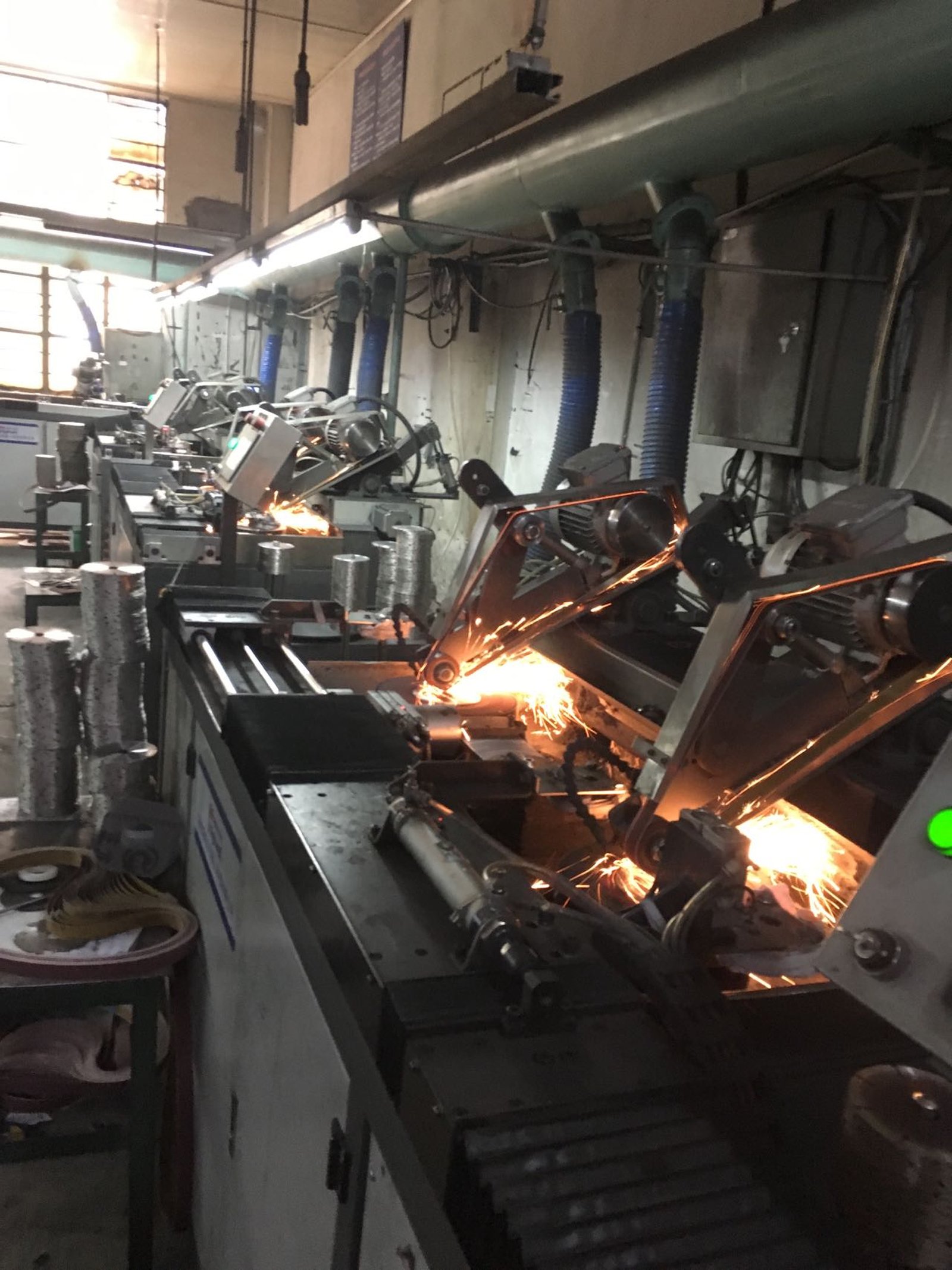 Automatic welding stations brazing diamond segments onto blade cores, sparks flying